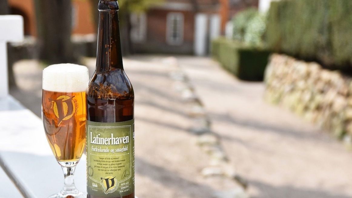 En øl fra Viborg Bryghus ses på en bænk i Viborg Domkirkekvarter